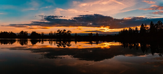 High resolution stitched summer sunset panorama with reflections near Aholming, Deggendorf,...
