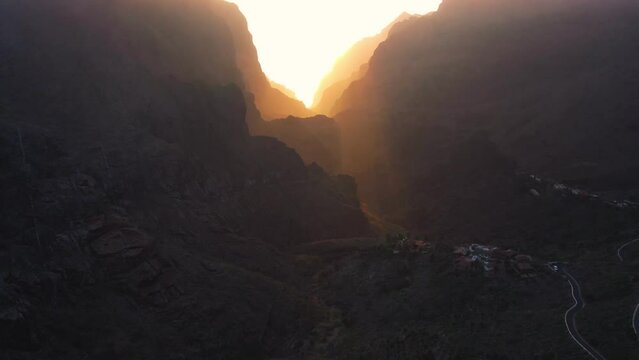 Aerial sunset of Masca valley. Asphalt road and cars on steep volcanic slopes of Tenerife Canary Islands