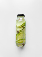 Detox drink with sliced lime in inside glass bottle, isolated on white background. High angle view with copy space. Freshness and hydration concept for health and wellness design.