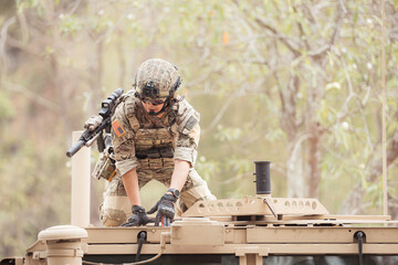 Soldiers in camouflage uniforms hold weapons ready to fire on the roof of a military communication...