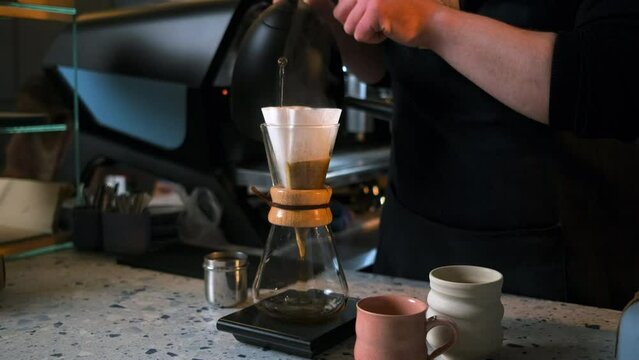Barista preparing filter coffee in a modern coffee shop.