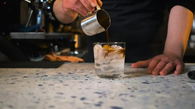 Close up of male barista hand making coffee tonic.