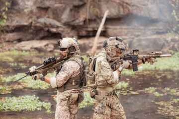 Soldiers in camouflage military uniforms carrying weapons, Reconnaissance missions in the tropical...