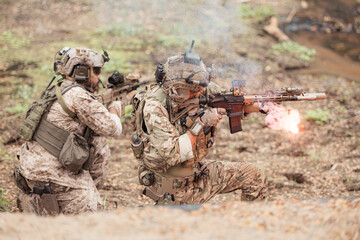 Fototapeta premium Soldiers in camouflage military uniforms carrying weapons, Reconnaissance missions in the tropical forest area, Assault infantry battle training.