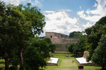 Fototapeta na wymiar Governor's Palace with remains of the carvings behind the Gran piramid in the ancient city Uxmal lost in the tropical jungle