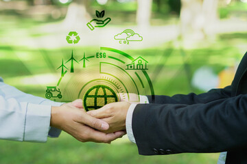 teamwork Hand hold green earth with Wind turbines, cars, ESG, houses, factories, recycling, carbon...