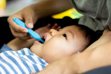 Boy doesn't like brushing his teeth and is sad, baby with her mother and brushing teeth