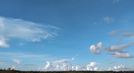Industrial landscape with blue sky and white clouds. Panoramic view.