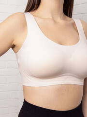 Woman in seamless bra top. Sporty light beige top