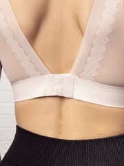 Woman in seamless bra top. Closure and lace straps. Wide closure
