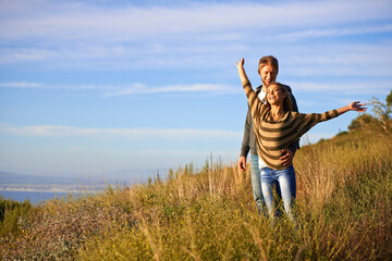 Spring, freedom and couple in nature, happy and bonding for holiday, vacation and trip to Amsterdam. Outdoor, man and woman together for love in field for anniversary of girl and male person