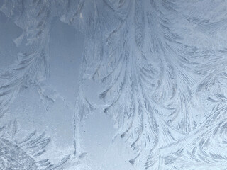 Winter frost patterns on glass. Ice crystals or cold winter background.