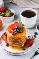 Pancakes with honey and berries on a plate