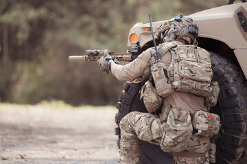 Soldiers in camouflage uniforms hold weapons ready to fire, By hiding on the side military...