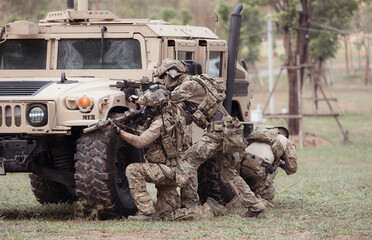 Group of soldiers in camouflage uniforms hold weapons in a jltv car, Plan and prepare for combat...