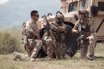 Group of soldiers in camouflage uniforms hold weapons in a jltv car, Plan and prepare for combat...