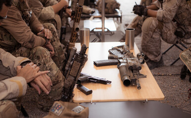 Group of soldiers in camouflage uniforms hold weapons in a field tent, Plan and prepare for combat...