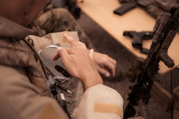 Group of soldiers in camouflage uniforms hold weapons in a field tent, Plan and prepare for combat...
