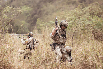 Soldiers in camouflage military uniforms carrying weapons, Reconnaissance missions in the tropical...