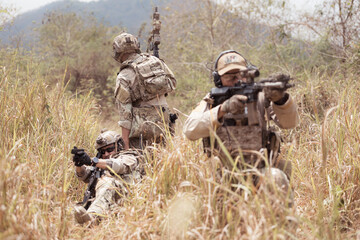 Soldiers in camouflage military uniforms carrying weapons, Reconnaissance missions in the tropical...