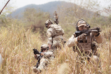 Soldiers in camouflage military uniforms carrying weapons, Reconnaissance missions in the tropical...