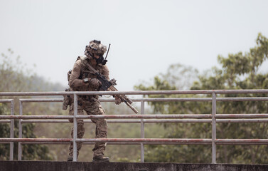 Soldiers in camouflage military uniforms carrying weapons, Reconnaissance missions in the tropical forest area, Assault infantry battle training.