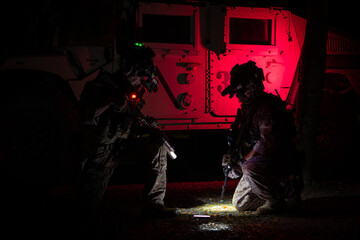 Group of soldiers in camouflage uniforms hold weapons with patrol missions at night
