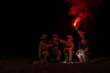 Group of soldiers in camouflage uniforms hold weapons with patrol missions at night