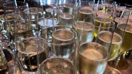 An assortment of tableware, filled with glasses containing beer, decorates the table at the event. The alcoholic beverage creates a fluid art in liquid form