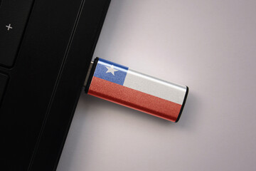usb flash drive in notebook computer with the national flag of chile on gray background.
