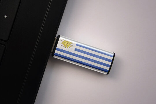 usb flash drive in notebook computer with the national flag of uruguay on gray background. - Powered by Adobe