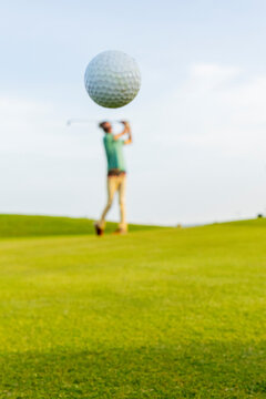Dynamic Golfer Launches Ball in Mid-Air on Green Course