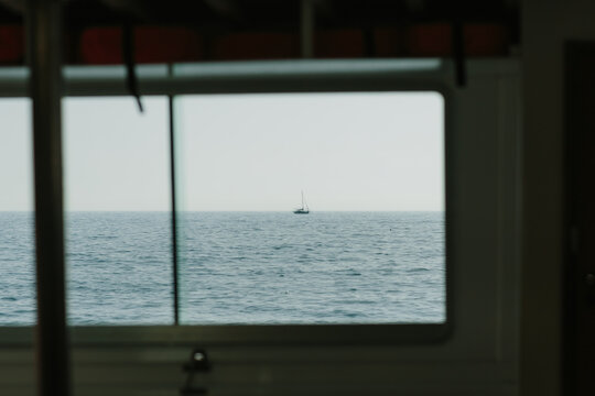 Sailing boat in the distance through window view