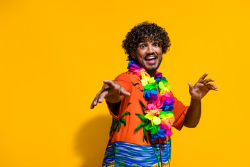 Portrait of eccentric guy with afro hair wear hawaii flower necklace dancing on vacation isolated on vibrant yellow color background