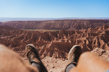 Pov view of legs of man on the top of a viewpoint in Devil's Gorge in San Pedro de Atacama, Chile