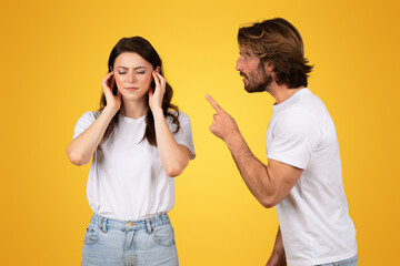 Stressed woman covering her ears while a man angrily points a finger at her