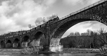 Historic steam train with old locomotive and passenger carriages on the Ruhr bridge near Witten on...