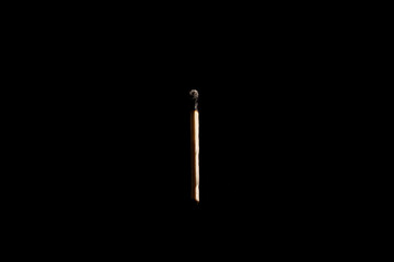 Lit falling match on a black background.