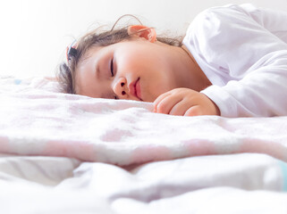 Obraz premium Rostro de hermosa bebe durmiendo tiernamente sobre su cama