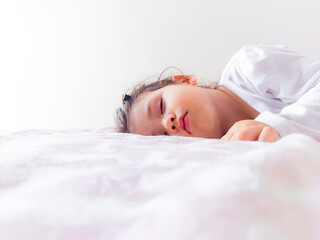 Rostro de hermosa bebe durmiendo tiernamente sobre su cama