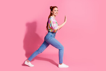 Fototapeta na wymiar Full size photo of funky pretty girl dressed colorful blouse jeans pushing product to empty space isolated on pink color background