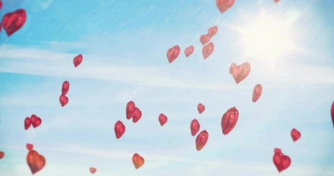 Animation of red heart balloons rising in sunny blue sky