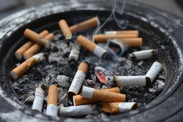 Ashtray with many cigarette butts and ash, smoking is harmful to health - obrazy, fototapety, plakaty