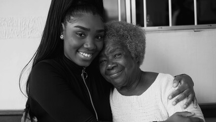 Tender loving moment of African American grandmother being held by teenage granddaughter in caring...