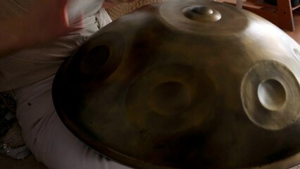 Hang drum played by young female. Female hands practicing native music traditional drumming instrument. High quality 4K footage.
