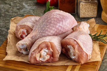Raw uncooked chicken drumsticks over board