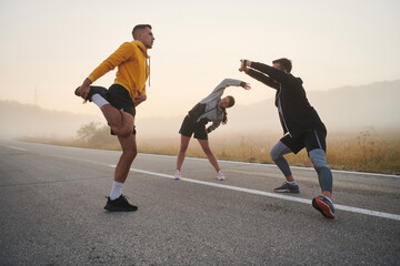 Diverse Athletes Prepare: Dynamic Group Warms Up for Morning Run.