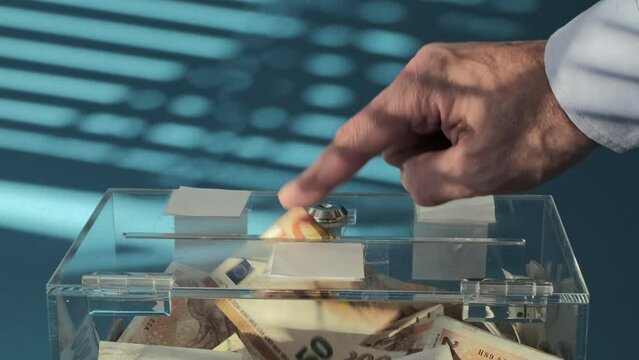 Hand give Charity in nominal 50 Euro banknotes to a transparent donation box for money donation. A financial support, collects money for a noble cause. The act of giving supports 