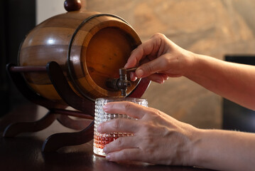 Hands pouring a drink from a barrel
