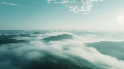 Obraz premium clouds over the mountains, Misty green hills under a soft, hazy sky. Serenity and nature concept. Design for tranquility, landscape beauty, and peaceful solitude. Abstract and dreamy background with a